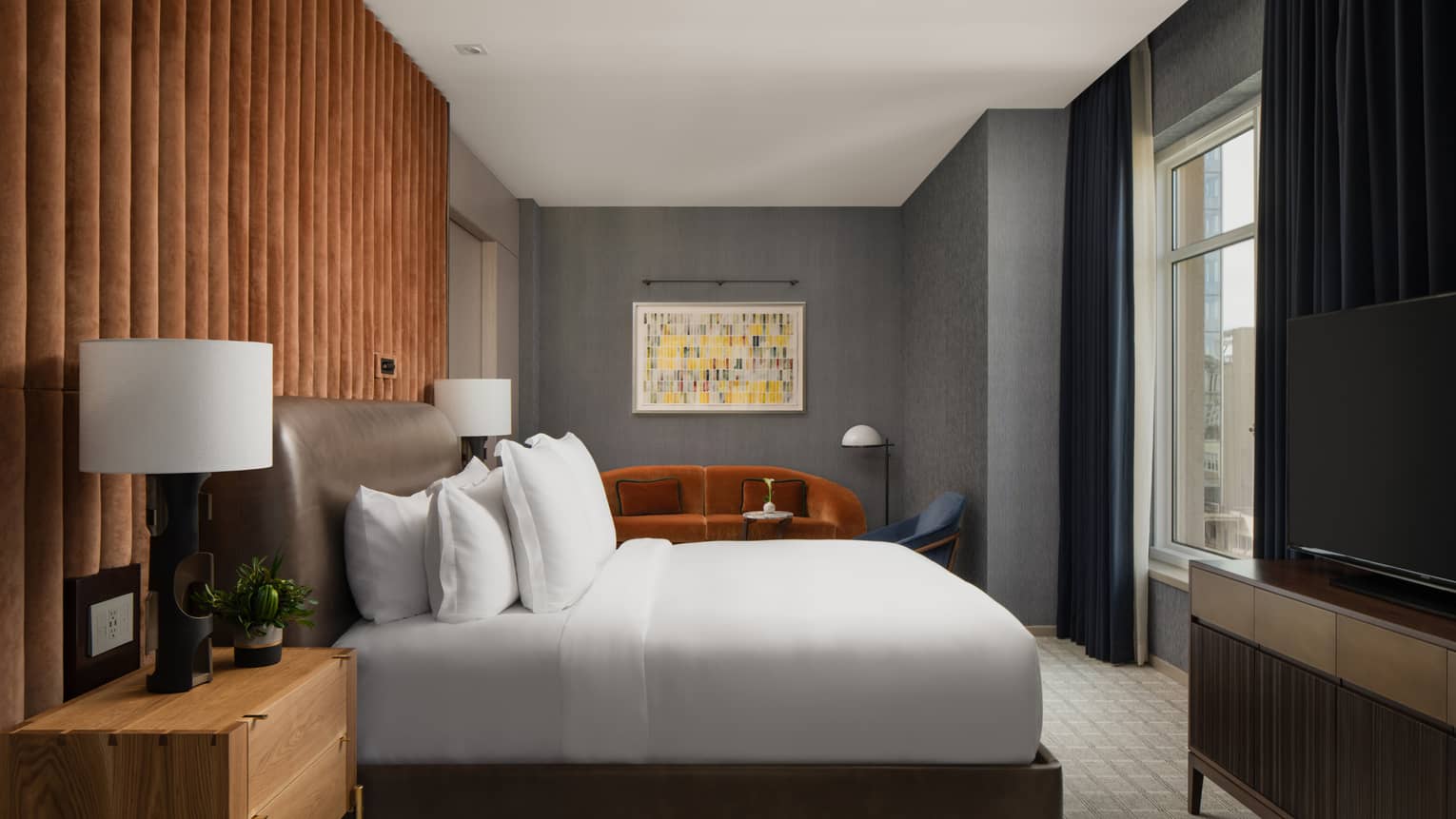 Hotel bedroom, a king bed with leather headboard and velvet accent wall