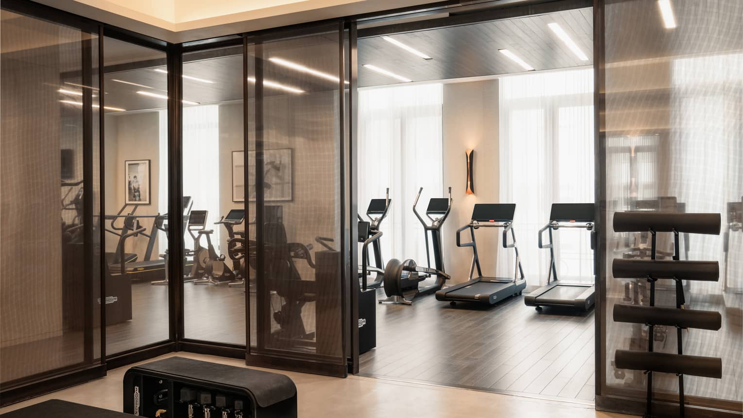 A Fitness Centre with exercise machines along the wall facing the windows