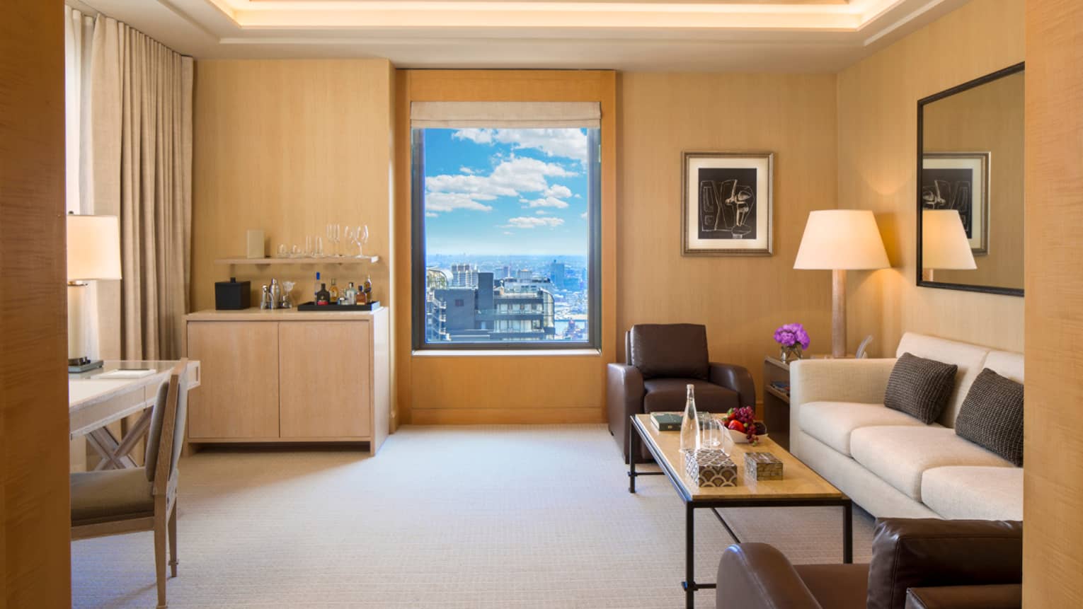 Park Avenue Suite small wet bar by window, white sofa with two brown leather chairs
