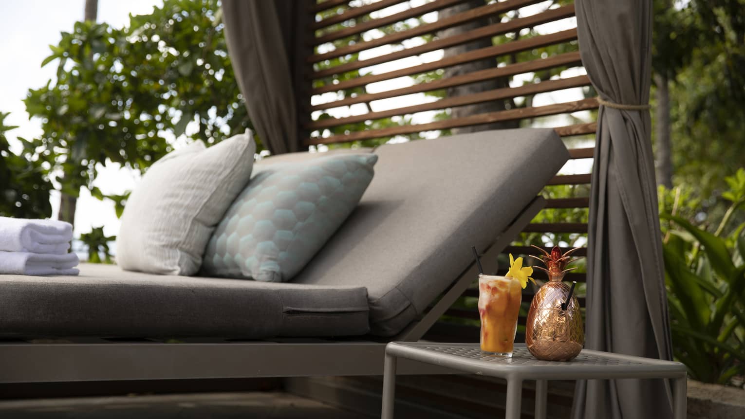 Cabana sunbed and cocktail in a tropical resort location
