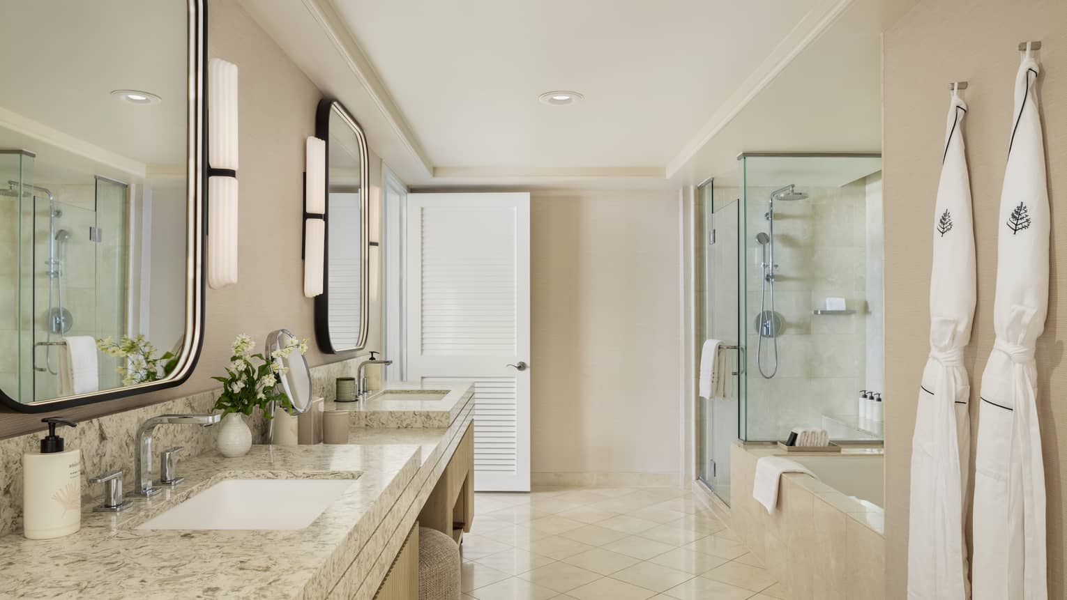Large resort suite bathroom featuring double vanity sinks, a sunken tub and separate glass shower