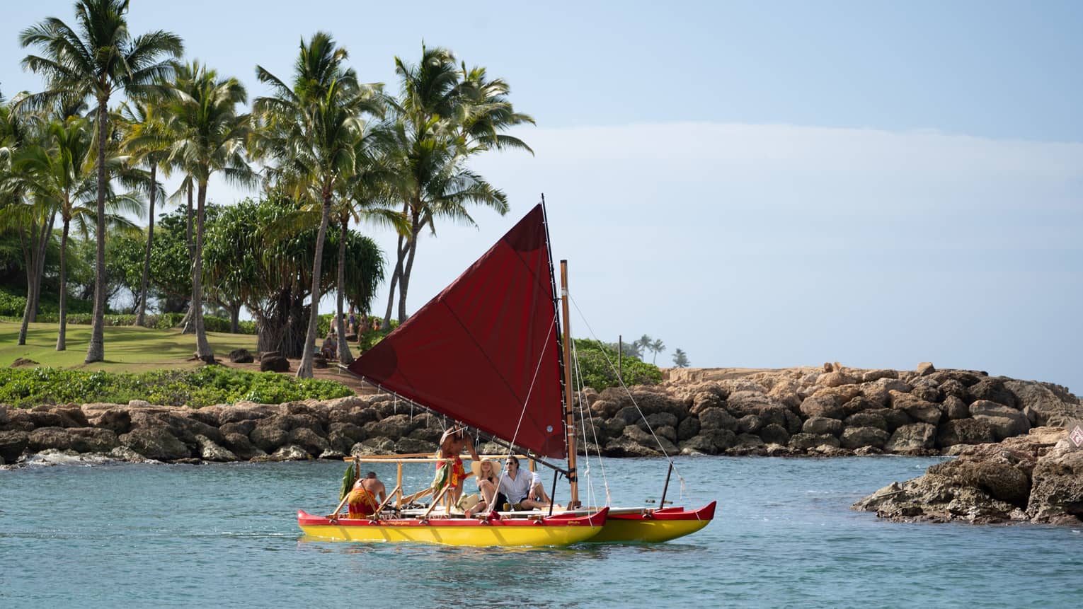 People sail in a traditional Hawaiian canoe in a lagoon
