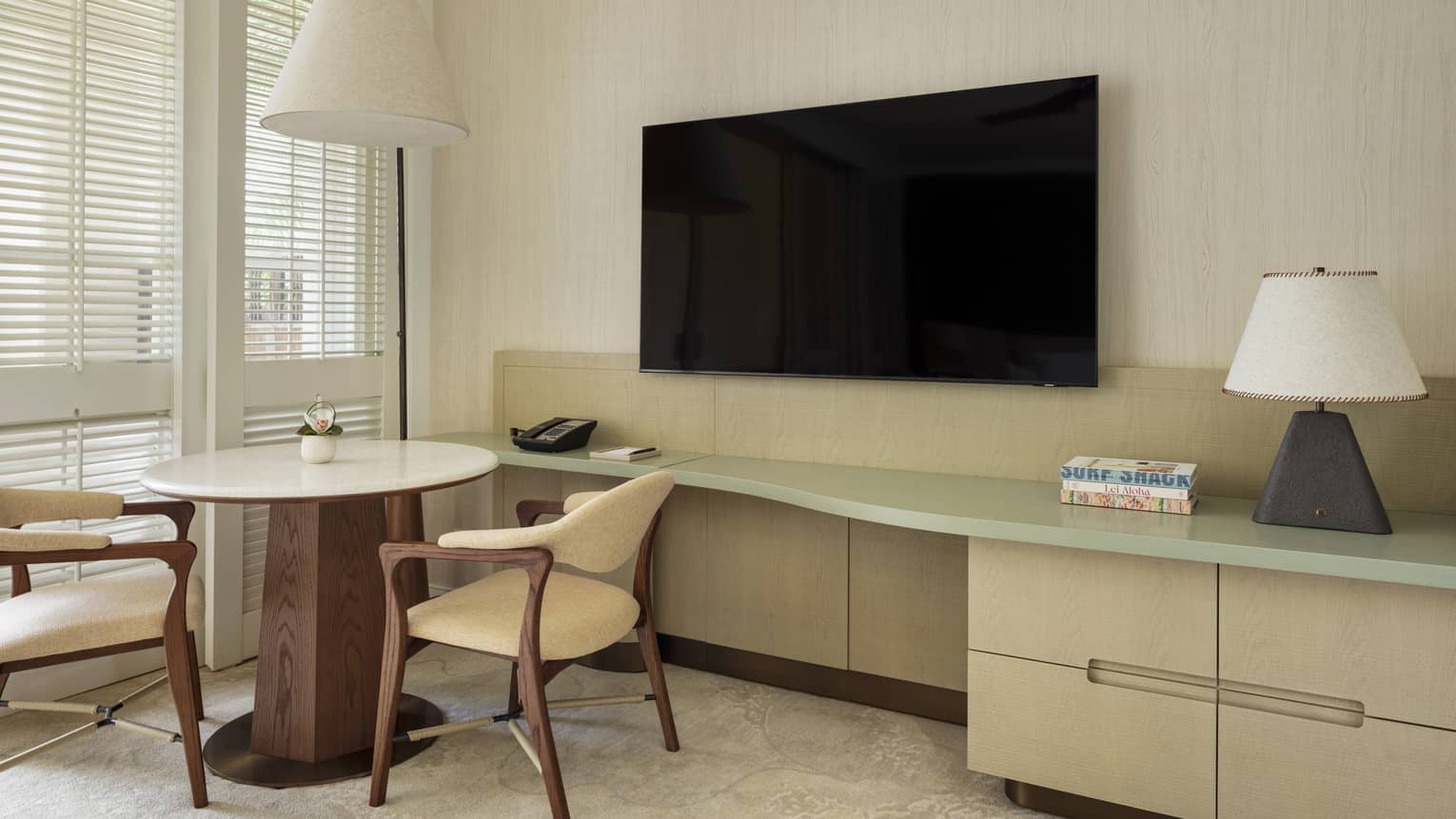 Contemporary resort room featuring a round table with two chairs by a TV