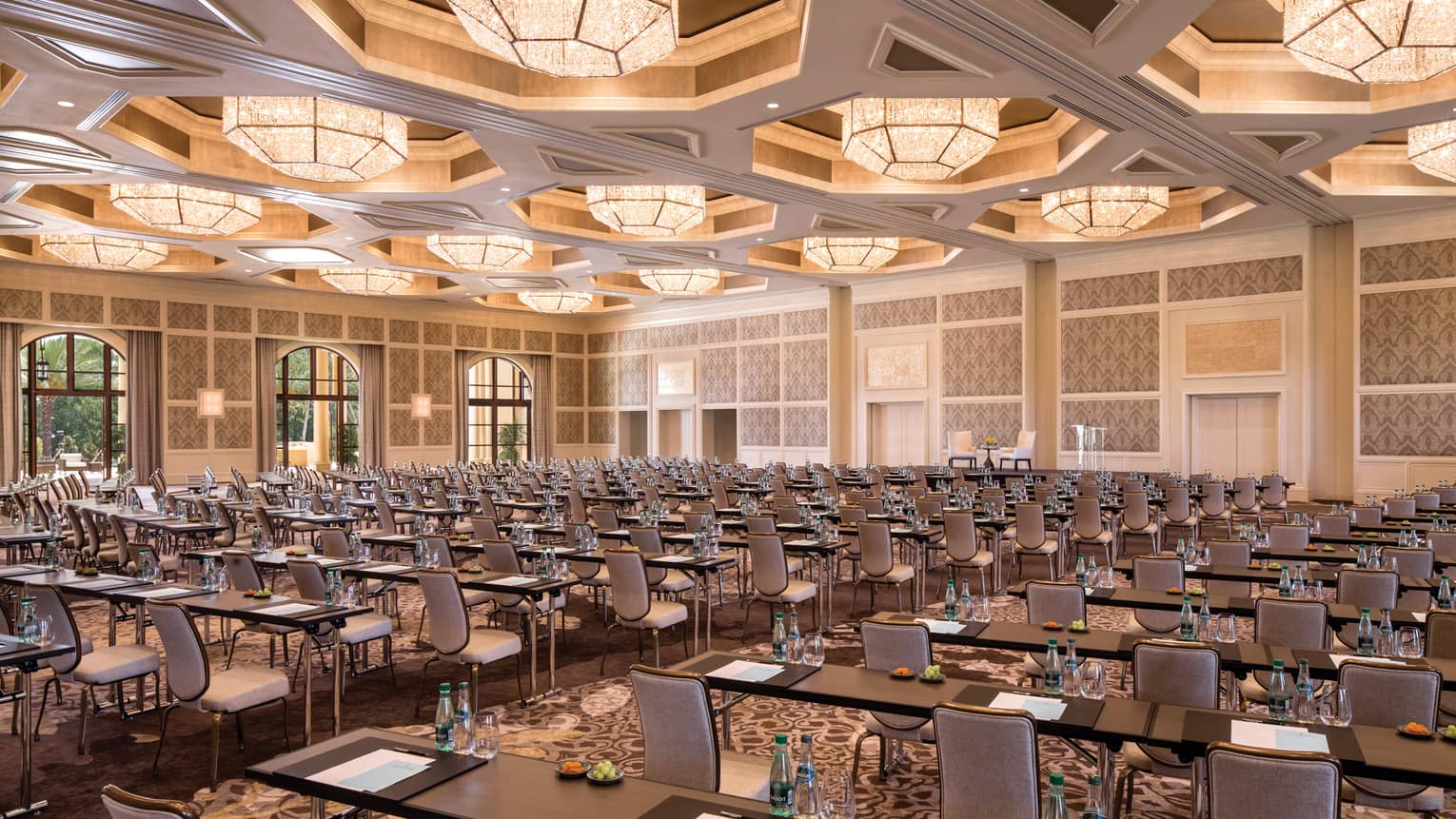 Rows of meeting tables, chairs in large Grand Ballroom under lights 