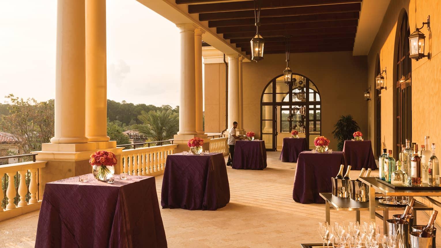 Sunny Grand Ballroom West Terrace with cocktail tables, wine station under pillars