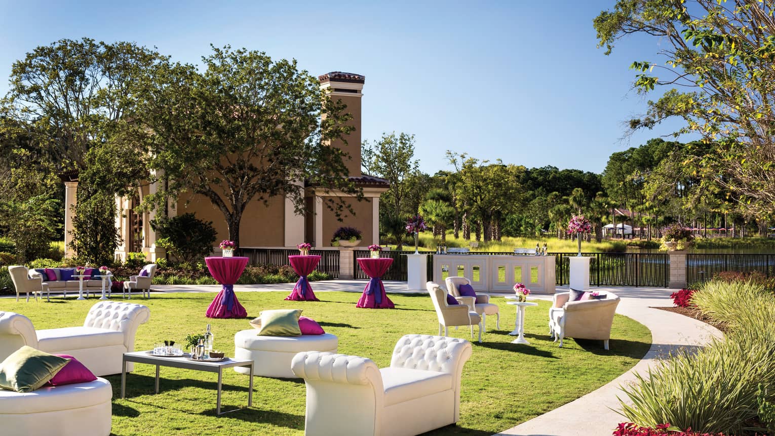 Modern white sofas, cocktail tables along path on sunny King Meadow event lawn
