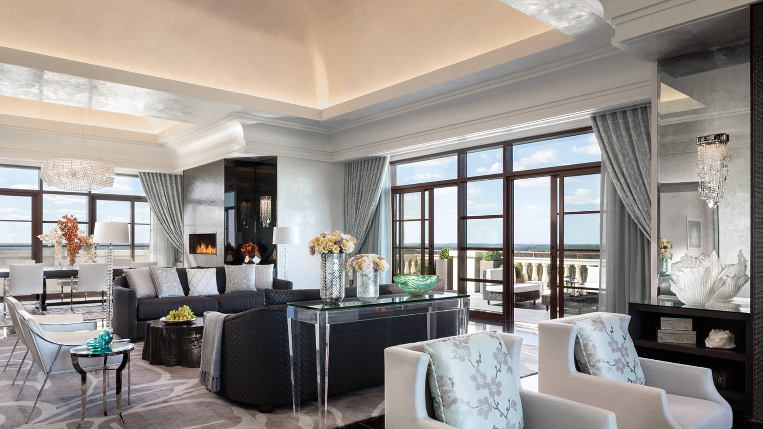 Royal Suite two seating areas in bright room under soaring ceilings, corner floor-to-ceiling windows