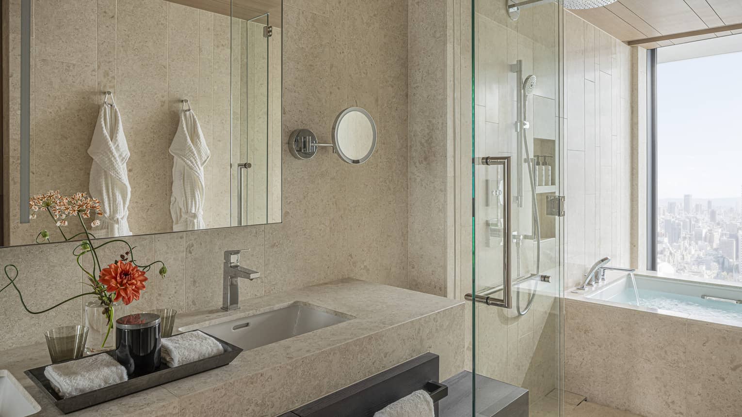 Modern hotel room bathroom with large window next to a luxury bath tub