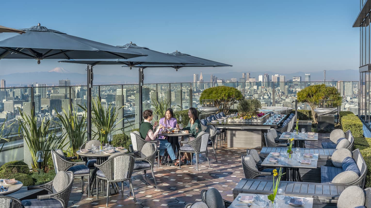 Group of three friends enjoy a meal on PIGNETO's open-air terrace