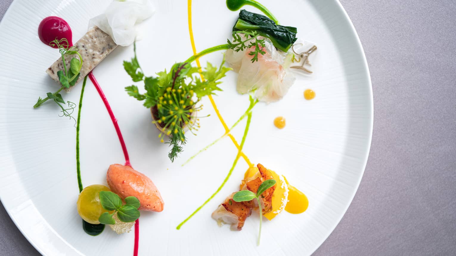 Small appetizers arranged on plate with artistic garnish