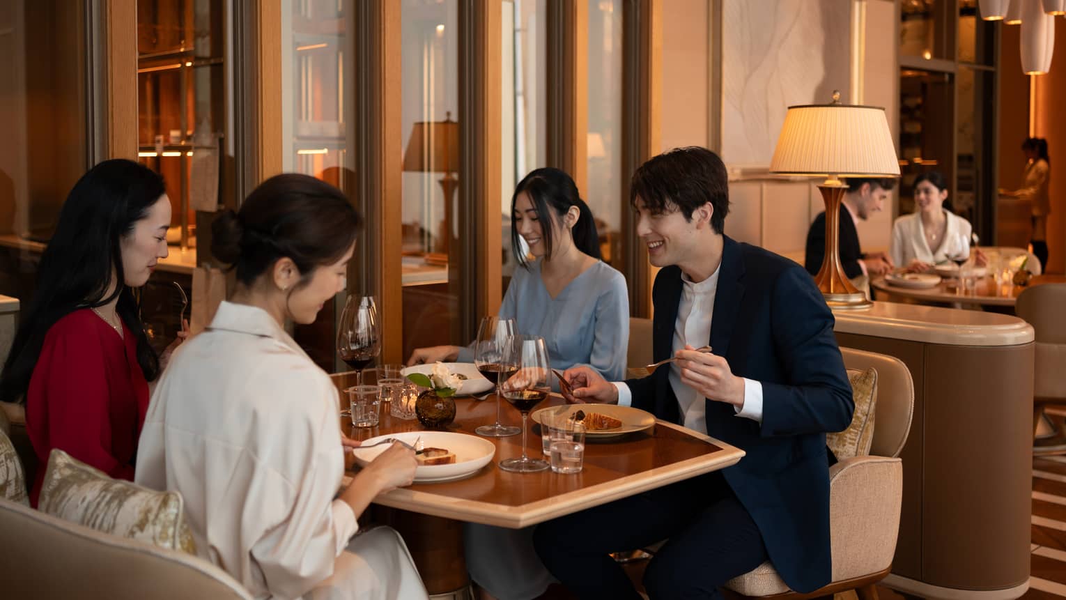 A group of friends eats at stylish restaurant table