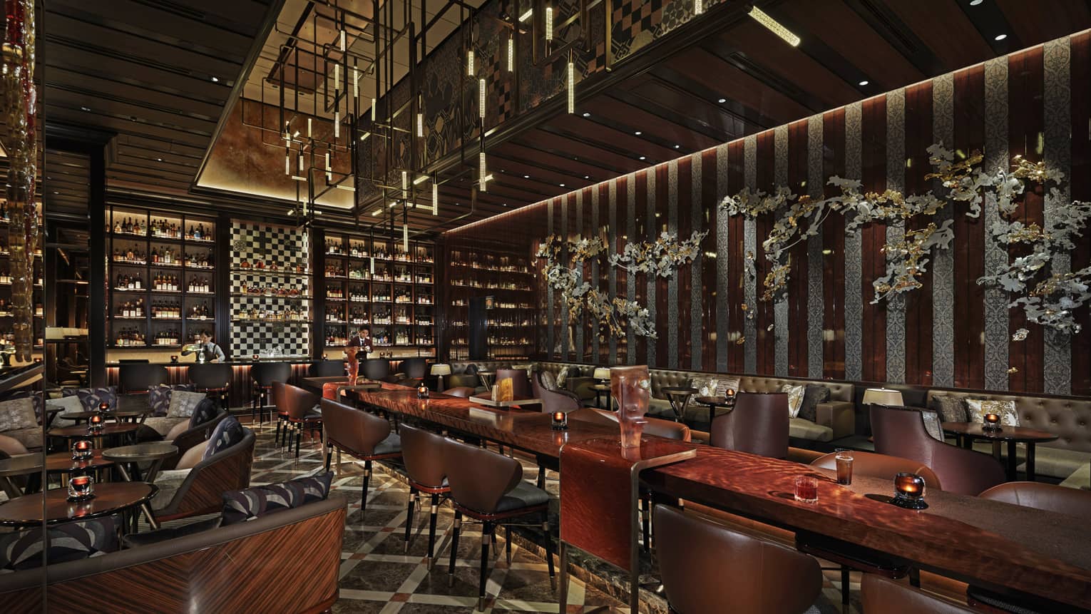 Long banquet tables with high-backed leather chairs, fully-stocked bar in the background, low-lighting, wood decor