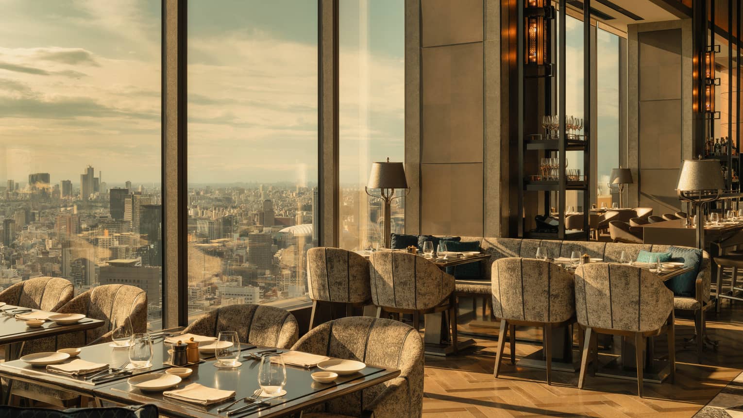 Luxury hotel restaurant with parquet floors, modern seating and floor-to-ceiling city views