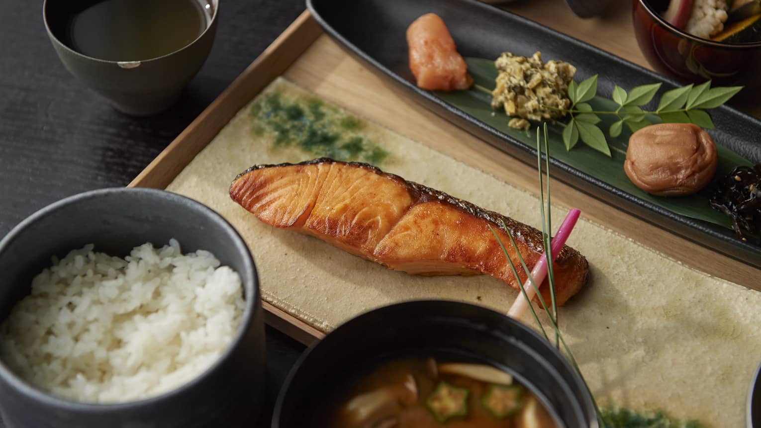 A Japanese style breakfast with rice, soup and grilled salmon.
