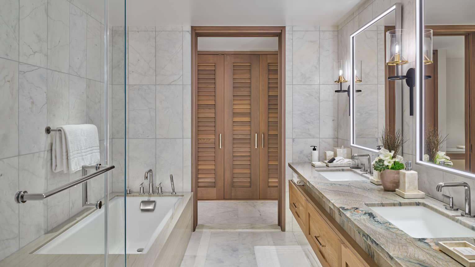 Marble bathroom with double vanity and tub