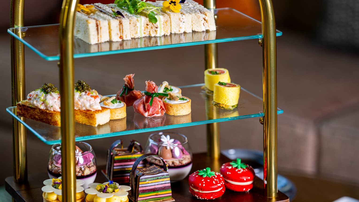 A tiered serving tray holds an assortment of colourful small bites.