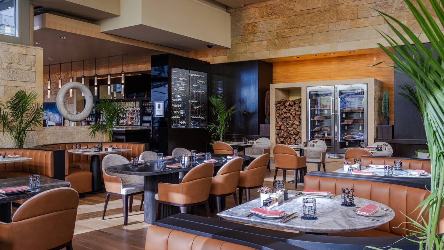 Restaurant with leather chairs and plants near the tables