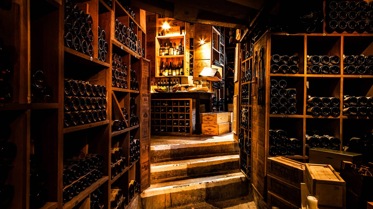 Vintage French wines line walls in dark wood cellar