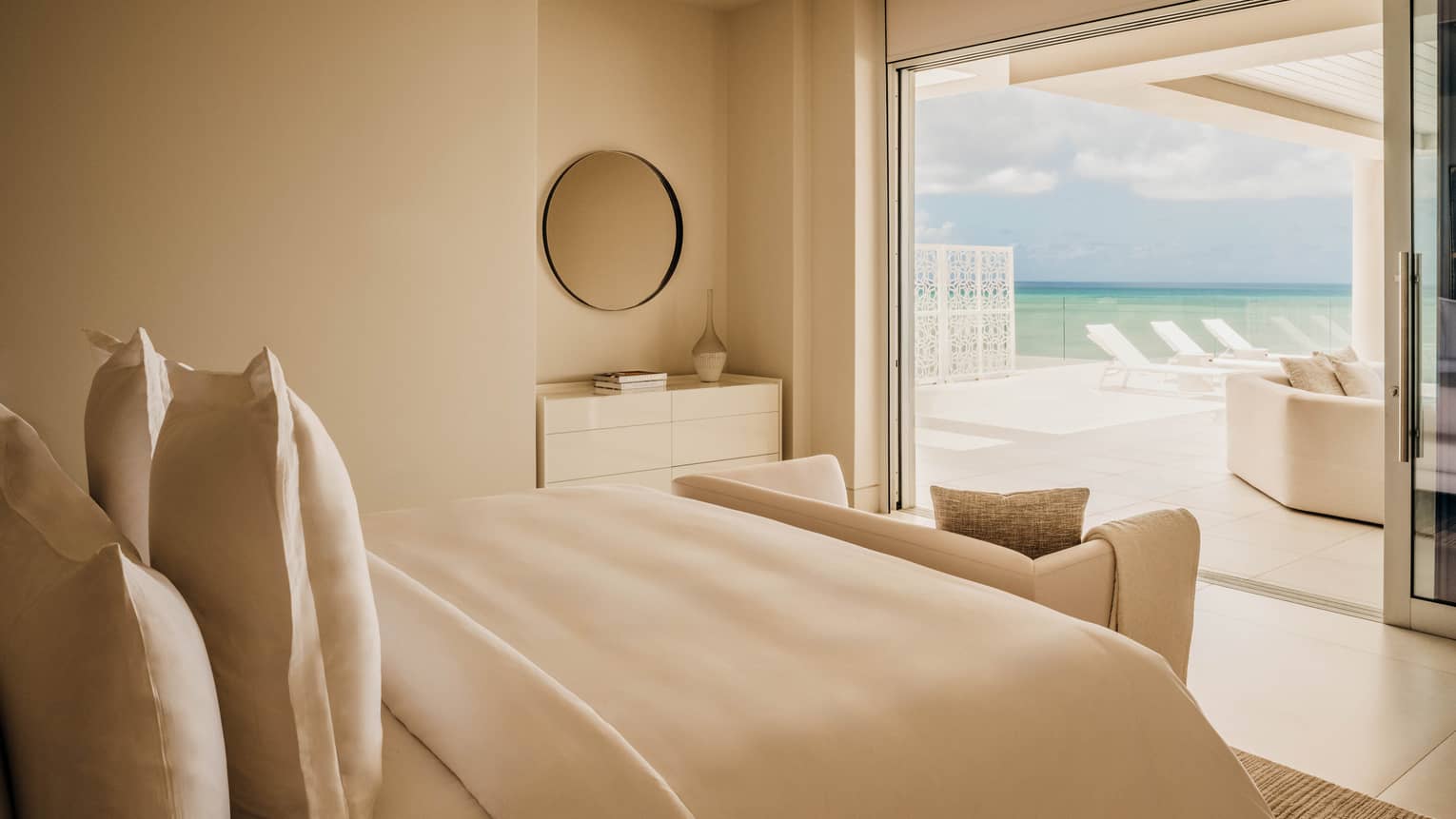Luxury bedroom opening up to a rooftop pool terrace overlooking the ocean