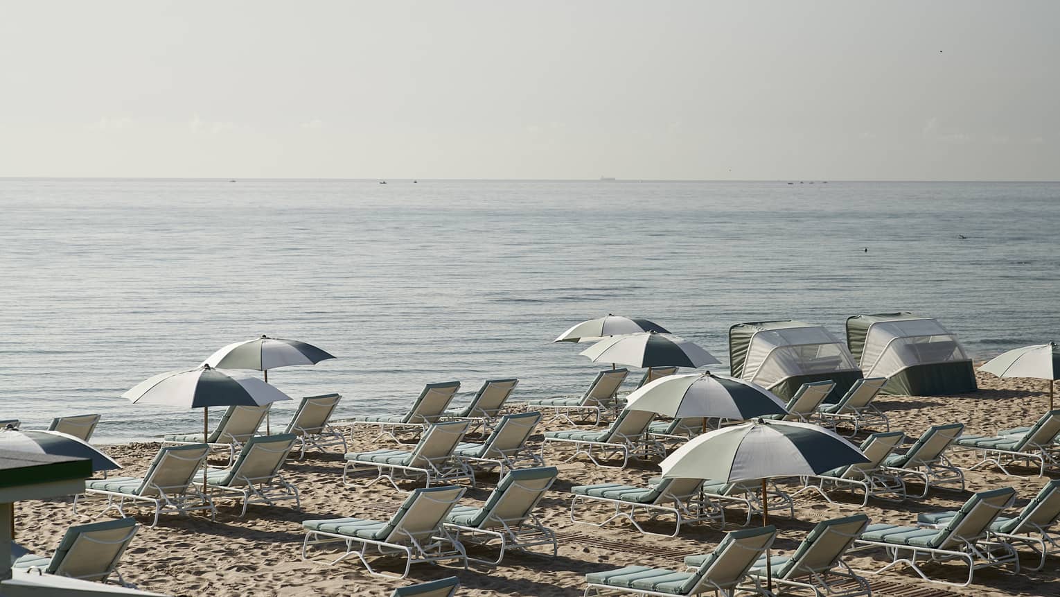 Lounge chairs and umbrellas on a sandy beach.