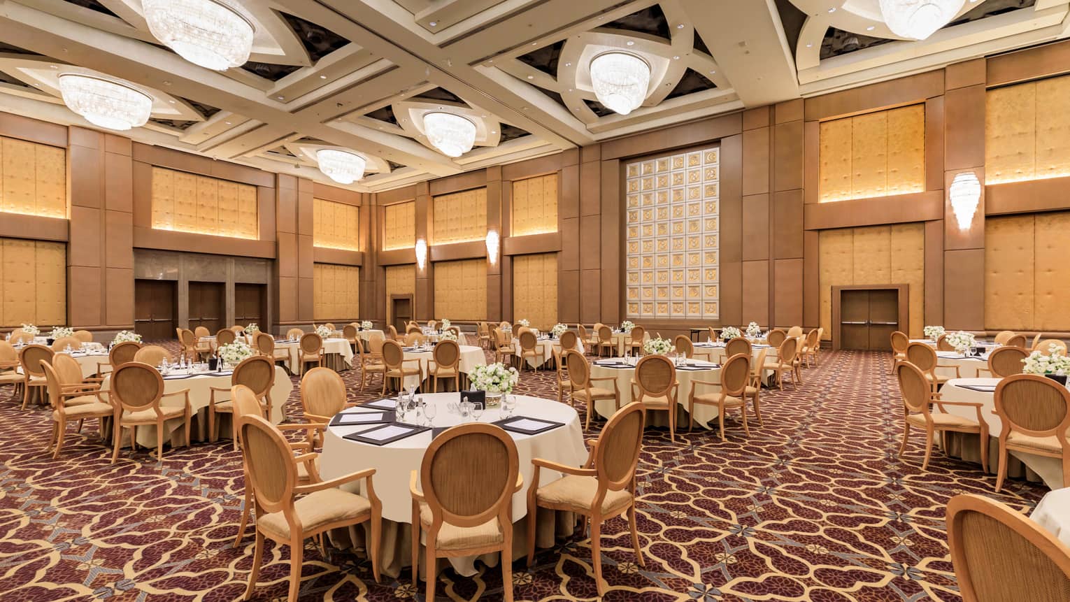 Banquet tables set for an event in a grand hotel ballroom