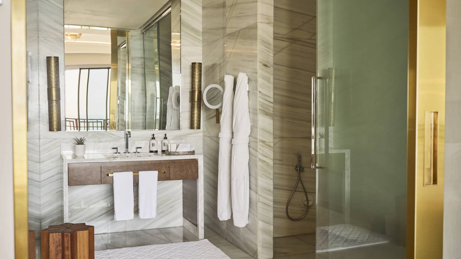 Hotel room bathroom with mobility-accessible glass shower