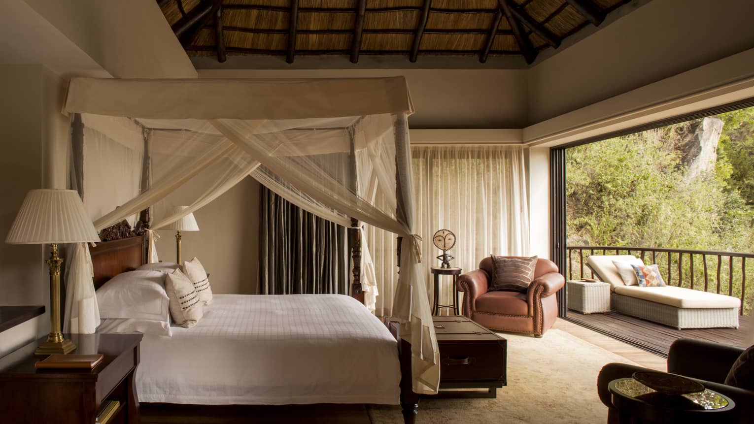 Two-bedroom villa side of poster bed with white canopy, open patio wall