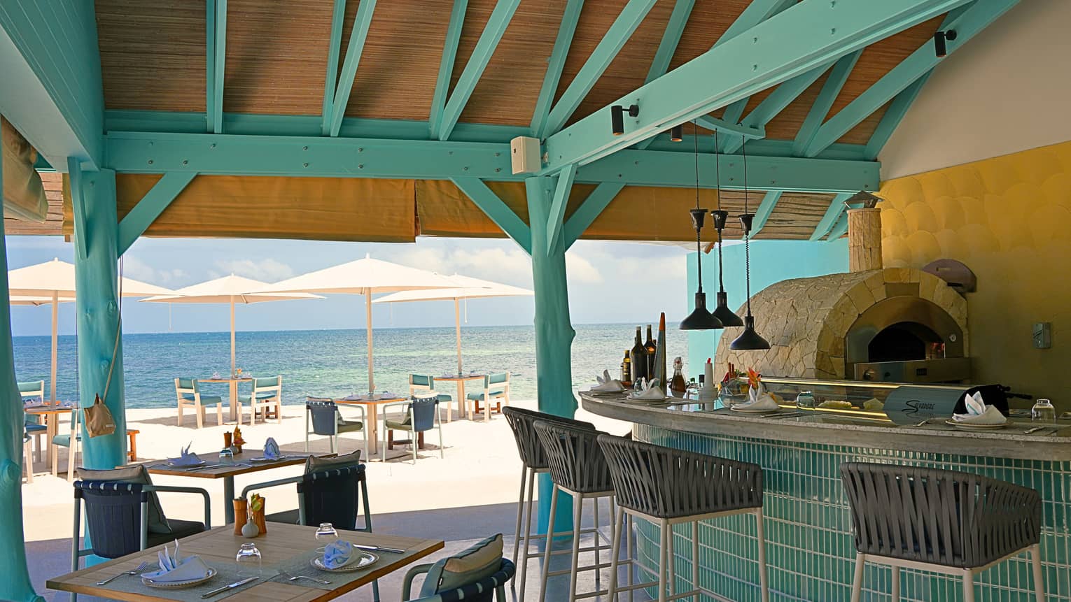 Covered outdoor restaurant with bar seating and an ocean view