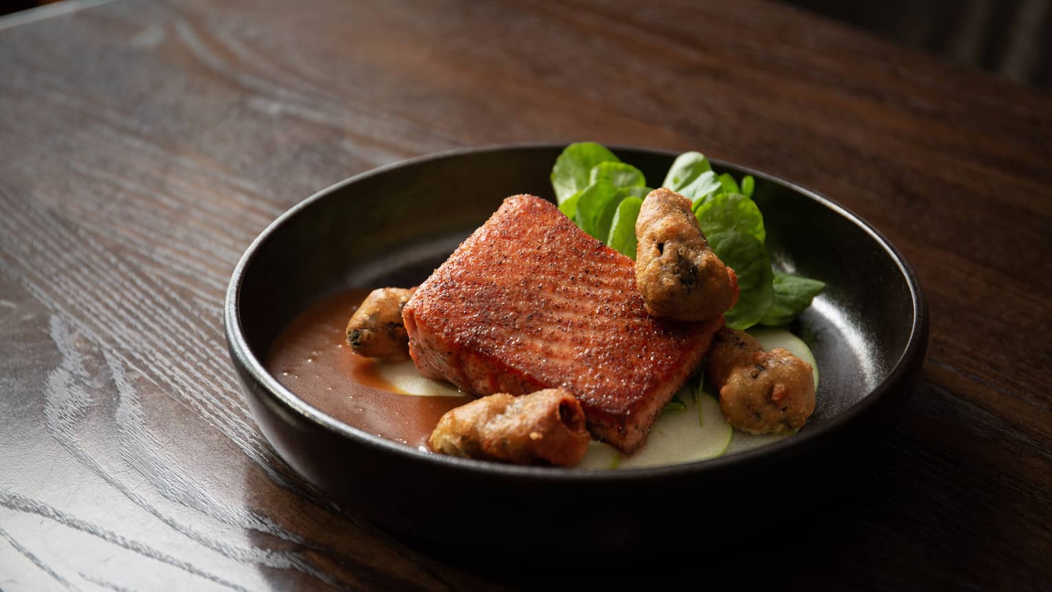 Salmon in a black bowl.