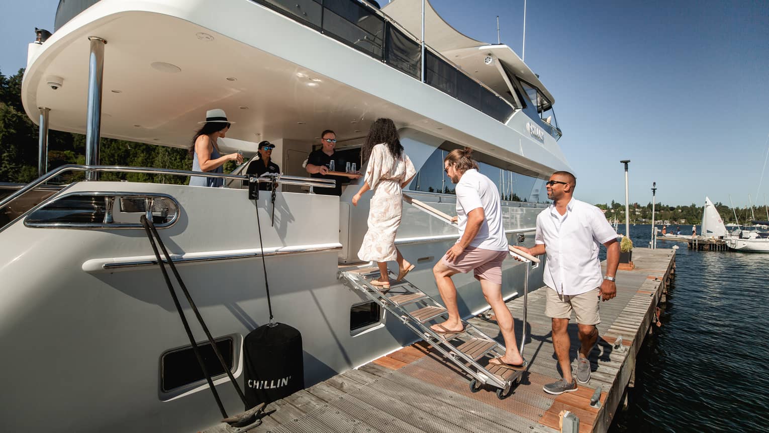 A group of people walking onto a boat at a dock.