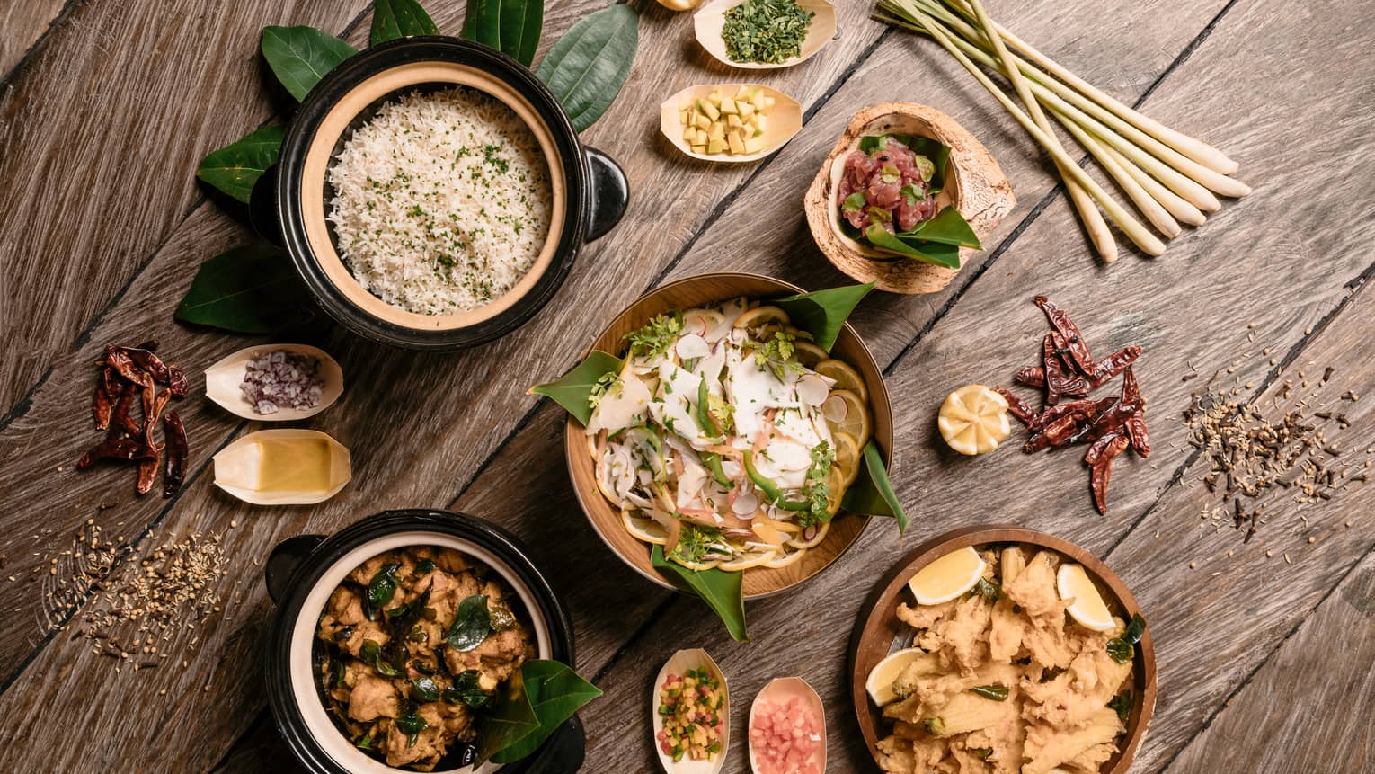 Aerial view of rustic wood table with bowls of gourmet rice, salads and entrees 
