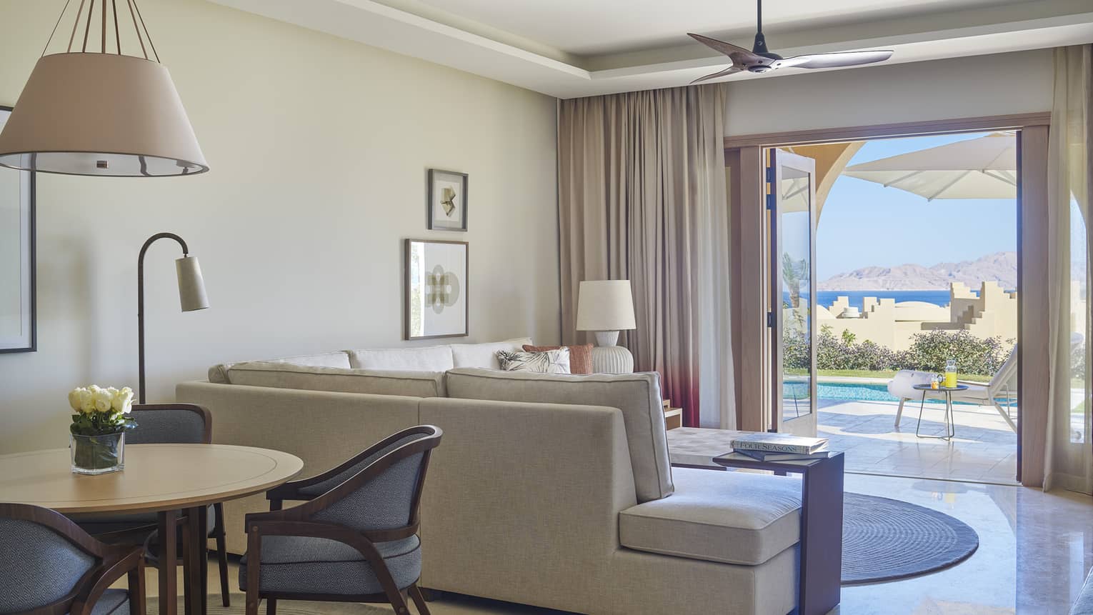 Living room with sectional sofa, walk-out terrace with pool