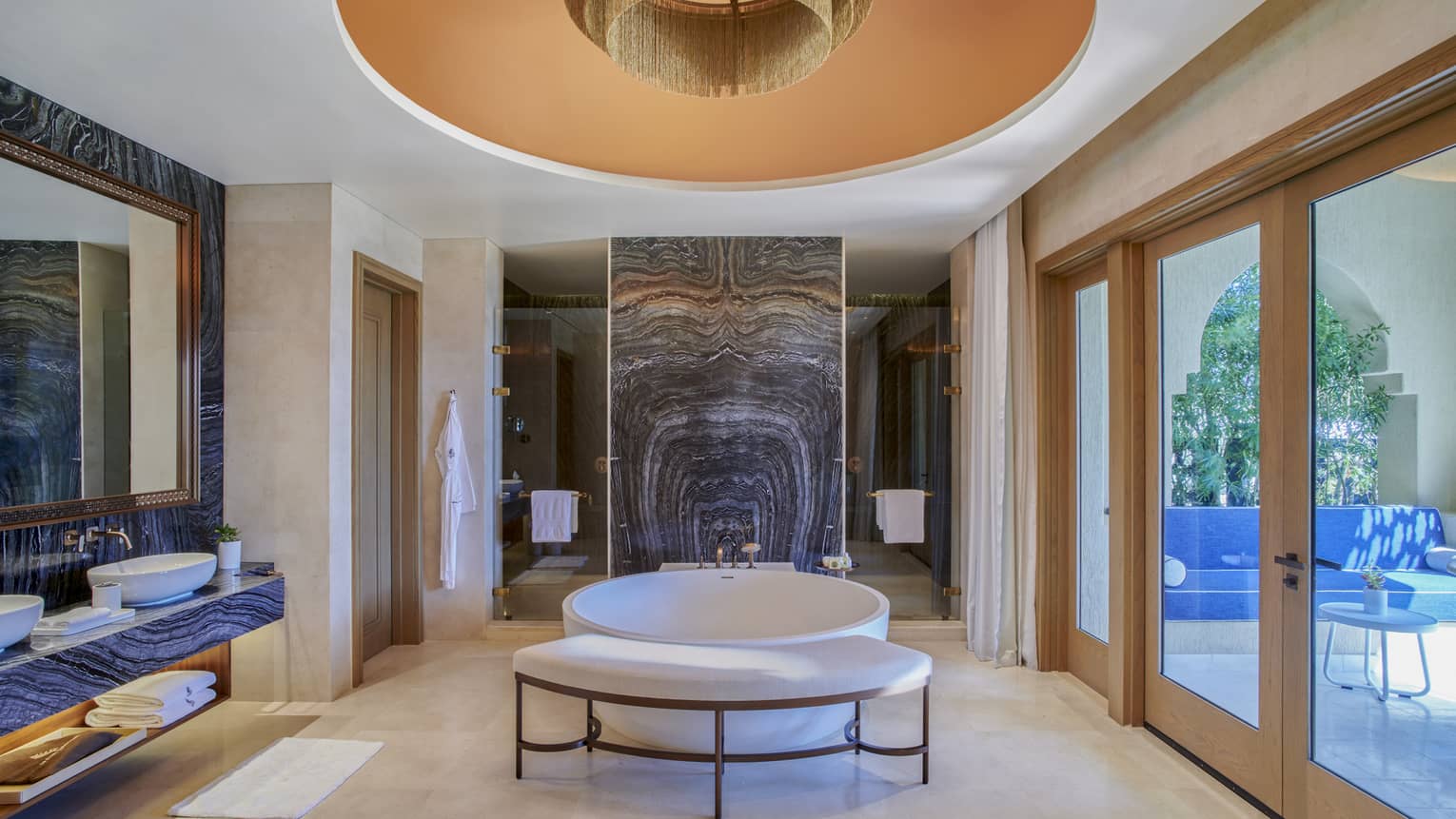 Large bathroom with round standalone tub in the middle, walk-out terrace
