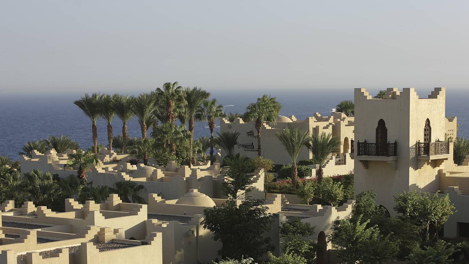 Aerial view over resort building and rooftops. palm trees