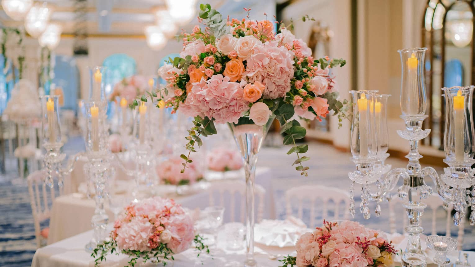 Tall glass vase with pink flowers, floral arrangements on wedding banquet dining table
