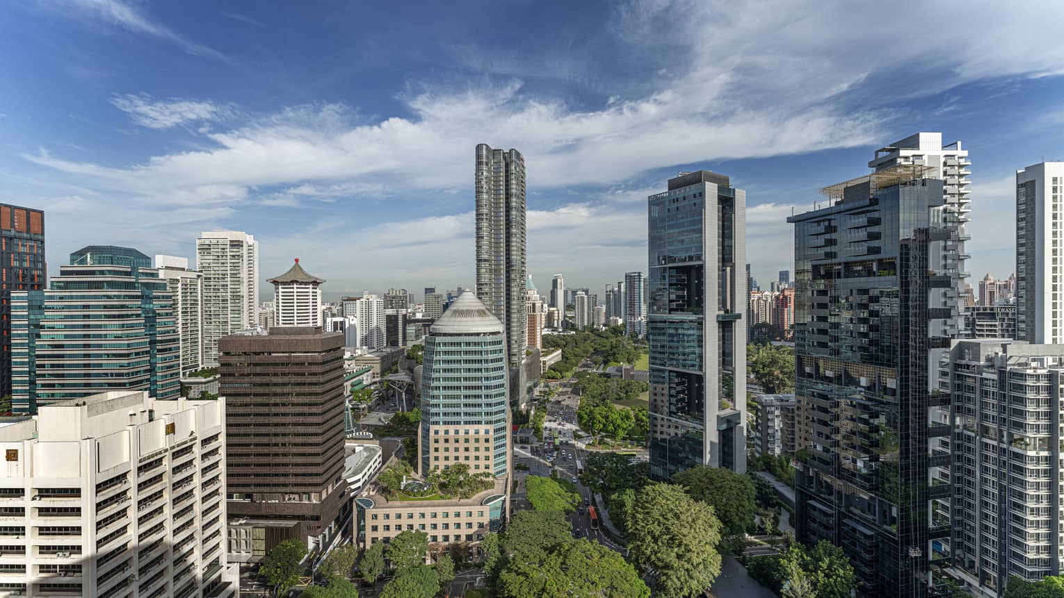 Bird's eye view of downtown Singapore, blue skies and trees