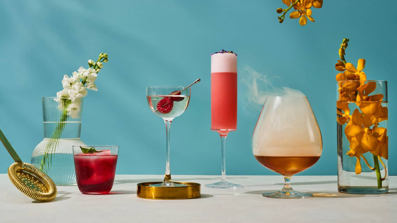 Assorted summer cocktails available at One-Ninety Bar with blue background