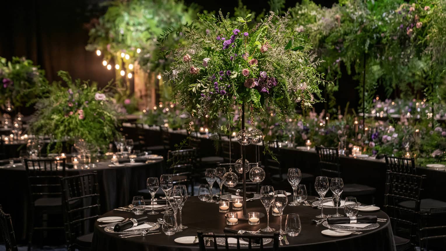 Wedding reception venue with fresh flowers and dark colour scheme