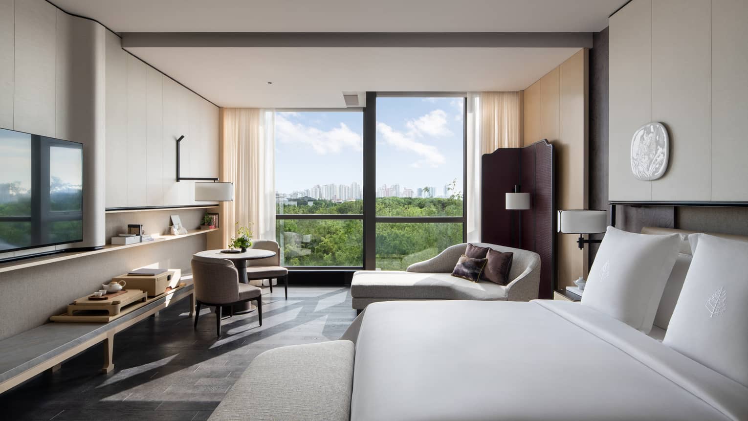 Luxury hotel room with king bed, chaise and small table with two chairs, at Four Seasons Hotel Suzhou