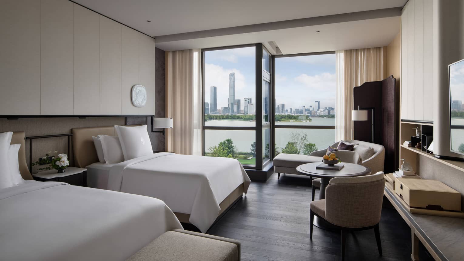 Luxury hotel room with two twin beds, chaise and lake view at Four Seasons Hotel Suzhou