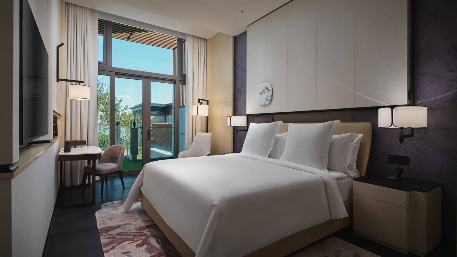 Hotel suite with king bed, desk and garden view at Four Seasons Hotel Suzhou