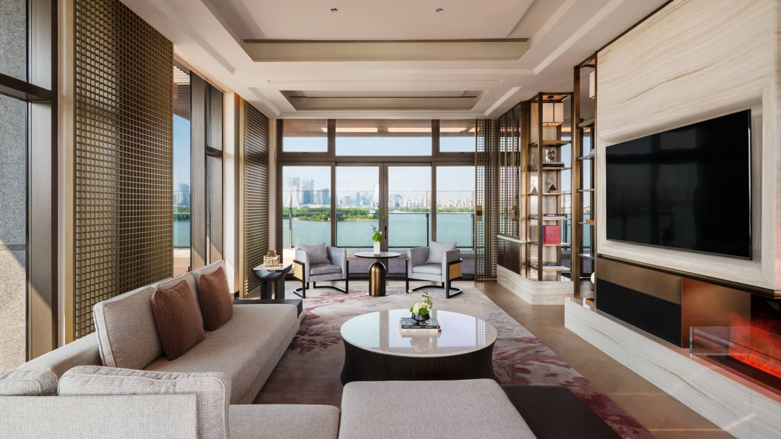 Large living room with sectional sofa, TV and lake-view terrace of Penthouse Suite at Four Seasons Hotel Suzhou
