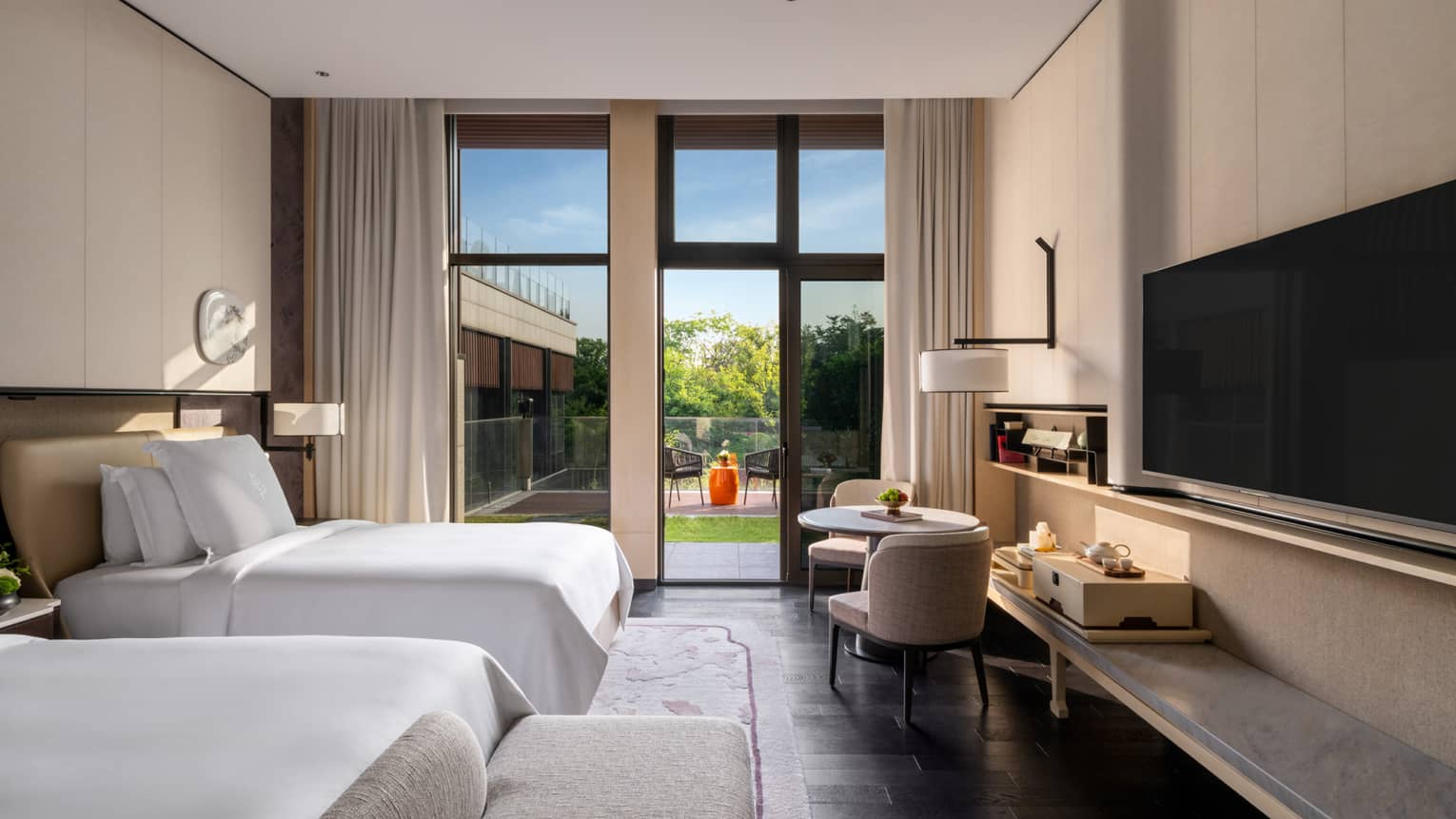 Luxury hotel room with two twin beds and garden terrace view at Four Seasons Hotel Suzhou