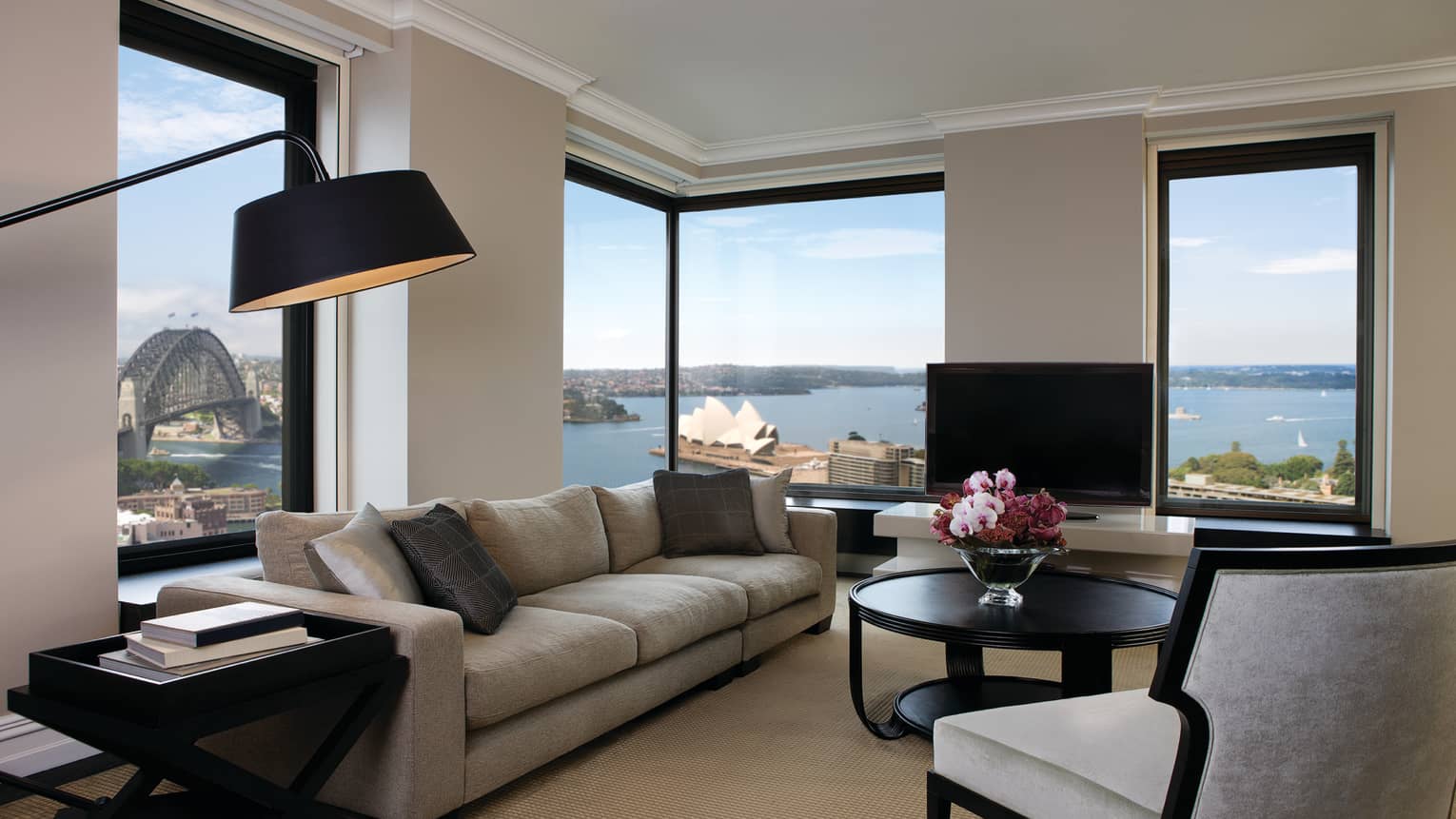 Presidential Suite reading lamp over long plush sofa, armchairs, table by sunny corner windows