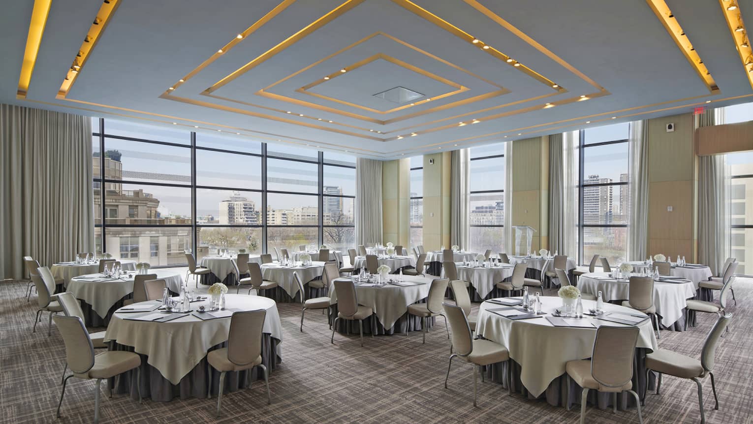 A series of circular tables adorned with white linen table cloths.