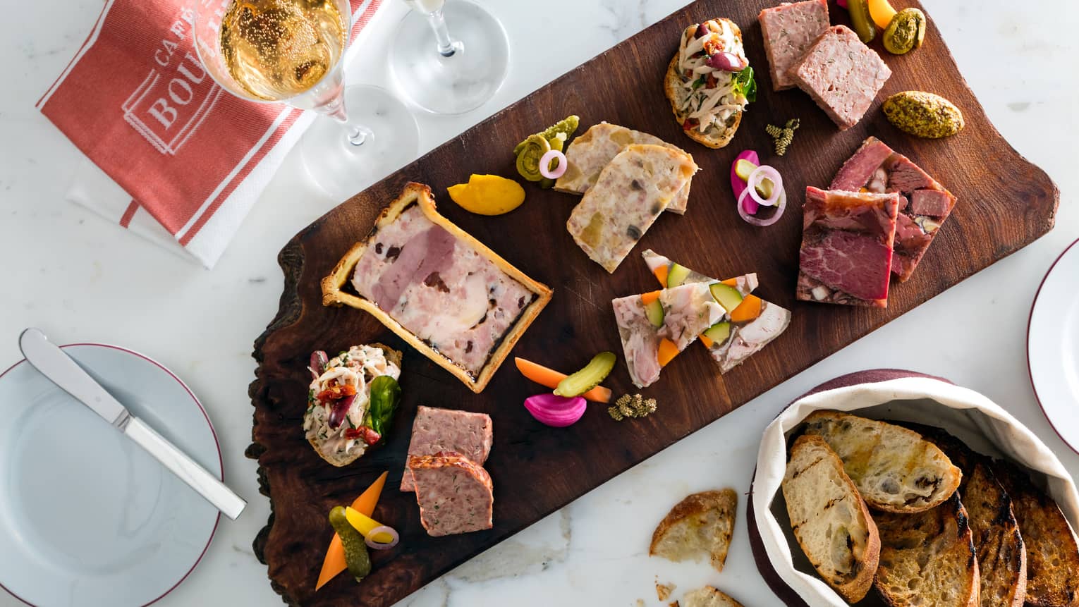 Aerial view of charcuterie board with pate, pickles, toasts