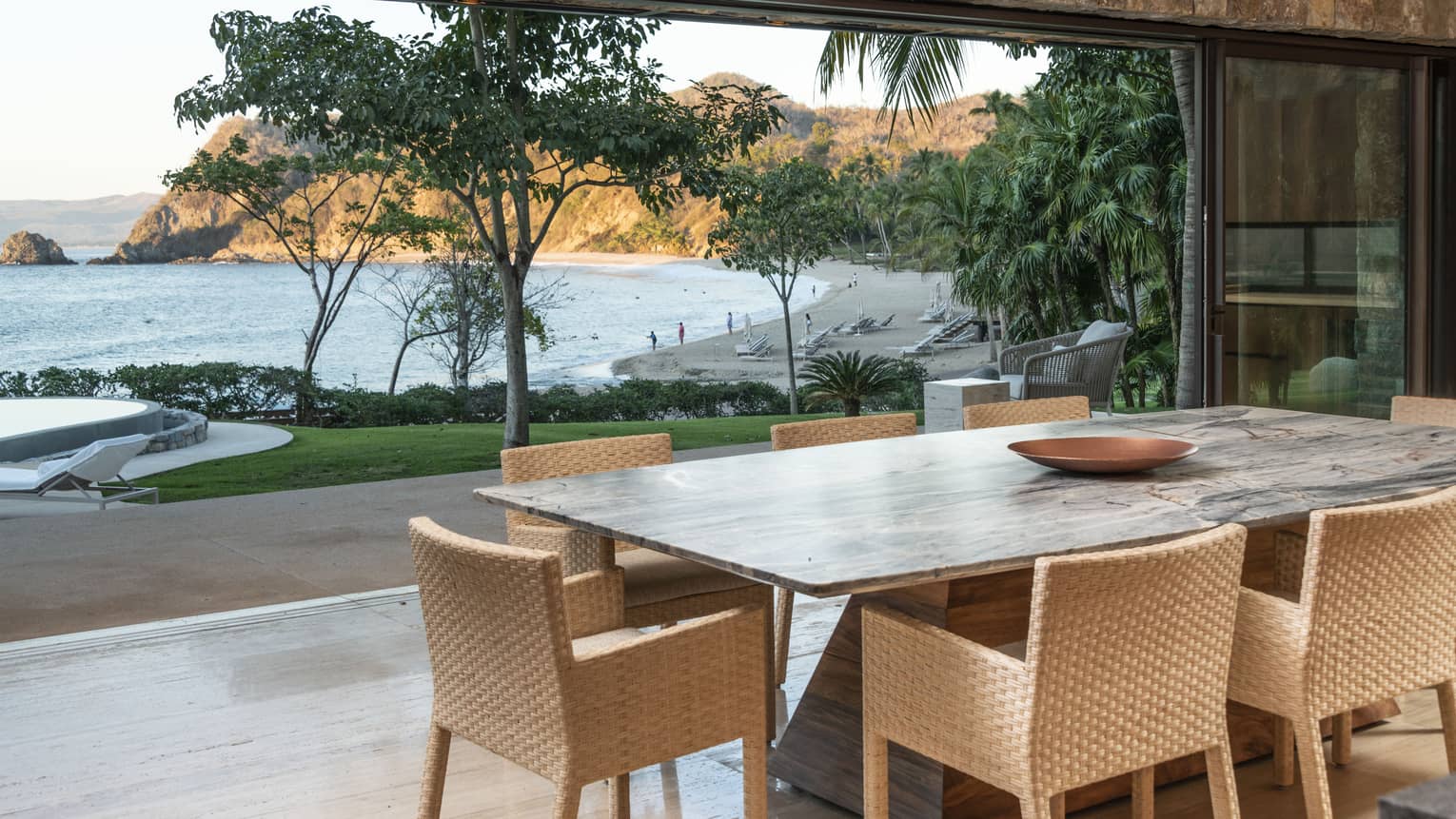 Dining table and open-air terrace with view of ocean and beach