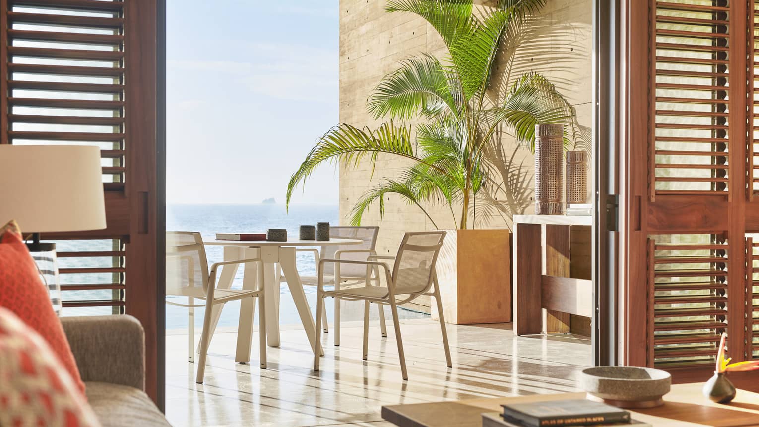 Private resort suite terrace with dining table and ocean view