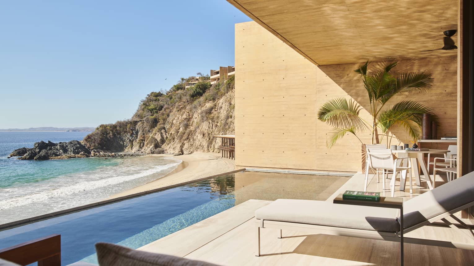 The exterior of a suite with a small pool next to the ocean.