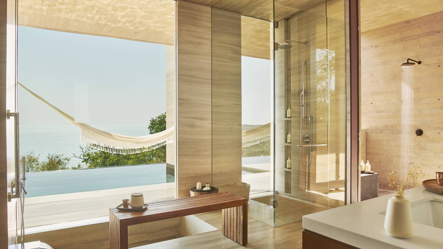 Indoor-outdoor, modern bathroom with infinity pool and ocean view